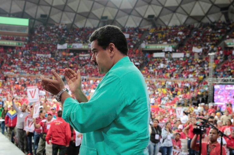 Venezuela's President Nicolas Maduro applauds as he attends a rally in Caracas