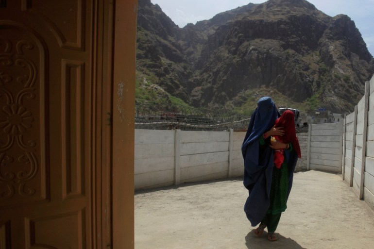 A woman coming from Afghanistan enters the information centre at the border post in Torkham, Pakistan [REUTERS]