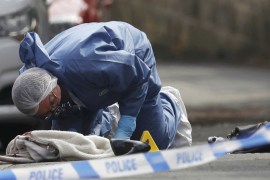 A forensics police officer works next women''s shoes and a handbag on the ground behind a police cordon in Birstall near Leeds