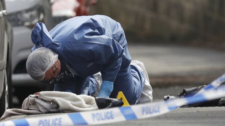 A forensics police officer works next women''s shoes and a handbag on the ground behind a police cordon in Birstall near Leeds