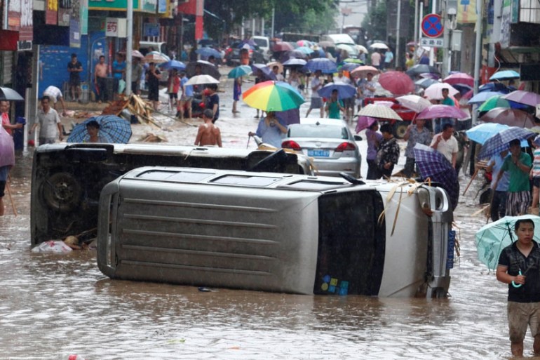 Automobiles are seen overturned on a flooded street in Liuzhou, Guangxi