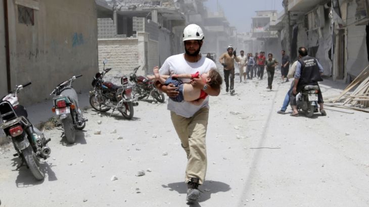 A civil defence member carries injured girl at site hit by airstrikes in rebel-controlled area of Maaret al-Numan town in Idlib province