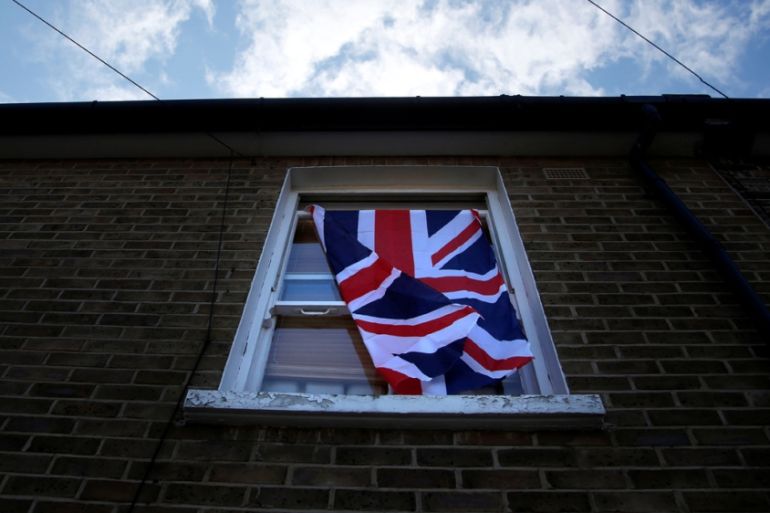 A British flag flutters in front of a window in London