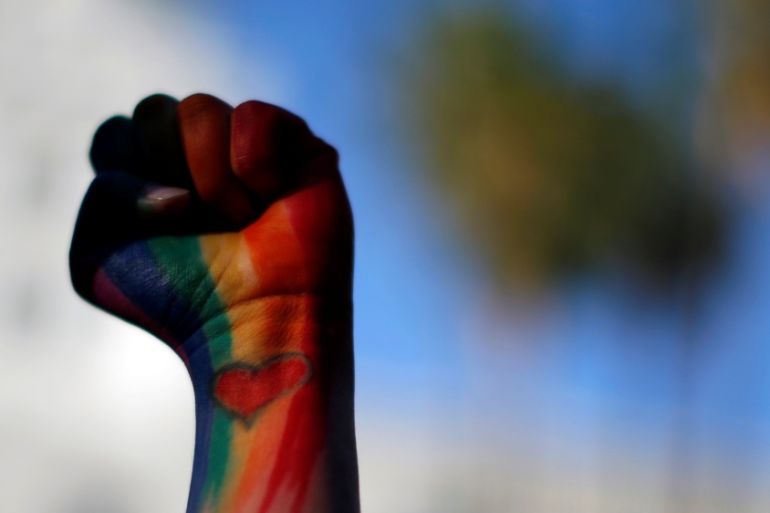 A mourner holds up her fist painted in the colours of a rainbow at a vigil in memory of victims one day after a mass shooting at the Pulse gay night club in Orlando [REUTERS]