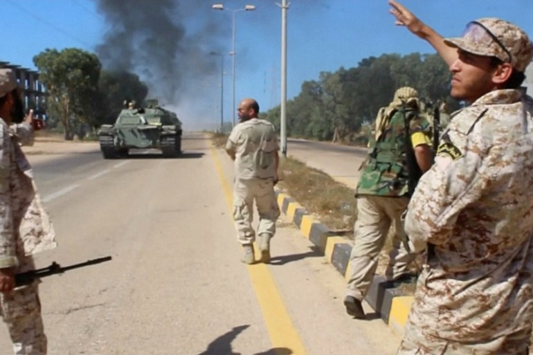 Still image of soldiers from a force aligned with Libya''s new unity government walking along a road during an advance on the eastern and southern outskirts of the Islamic State stronghold of Sirte