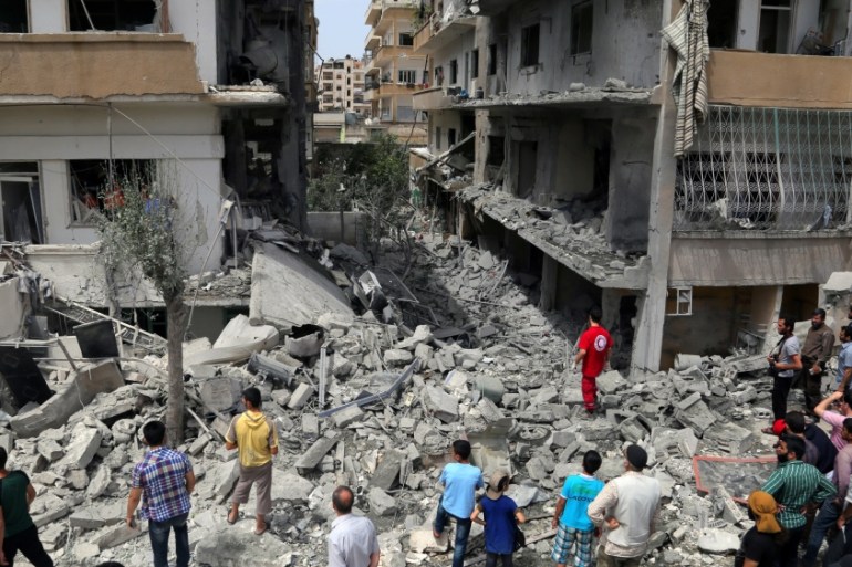 Rescuers and civilians inspect a site hit by an airstrike in Idlib, Syria [REUTERS]