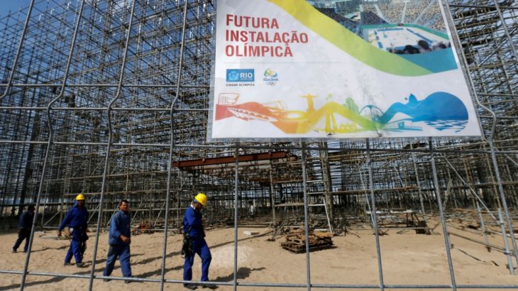 Workers are pictured at the construction site of the beach volleyball venue for 2016 Rio Olympics on Copacabana beach in Rio de Janeiro