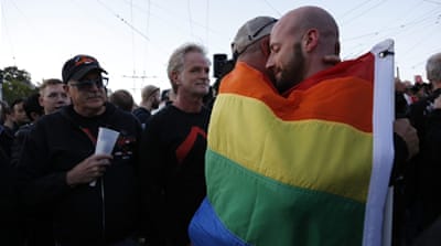 A couple hugs under a pride flag as residents of San Francisco and the Bay area gather to mourn the victims of a mass shooting at a LGBT nightclub in Orlando, Florida [EPA]