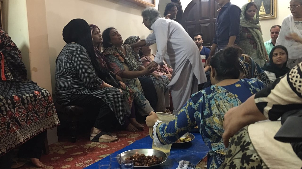 The sister of Amjad Sabir being consoled by relatives at her home in Karachi [Alia Chughtai/Al Jazeera]