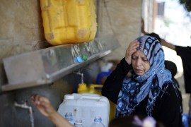 Palestinians fill bottles and containers with water from a public tap in Rafah in the southern Gaza Strip