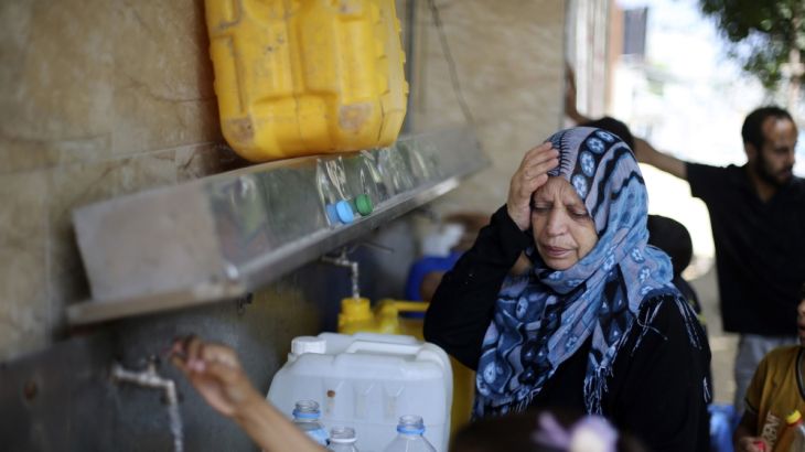 Palestinians fill bottles and containers with water from a public tap in Rafah in the southern Gaza Strip