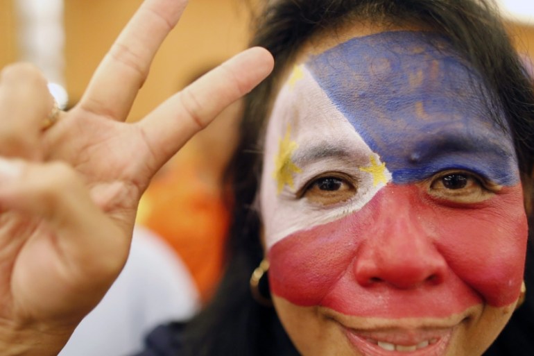 A Filipino activist gestures a victory sign during a celebration on the ruling on the disputed South China Sea in Manila, Philippines [EPA]