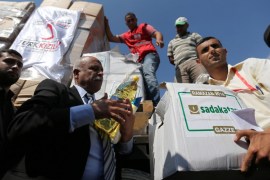 Palestinians unload Turkish aid shipments upon arrival in the Gaza Strip at Kerem Shalom crossing between Israel and southern Gaza Strip