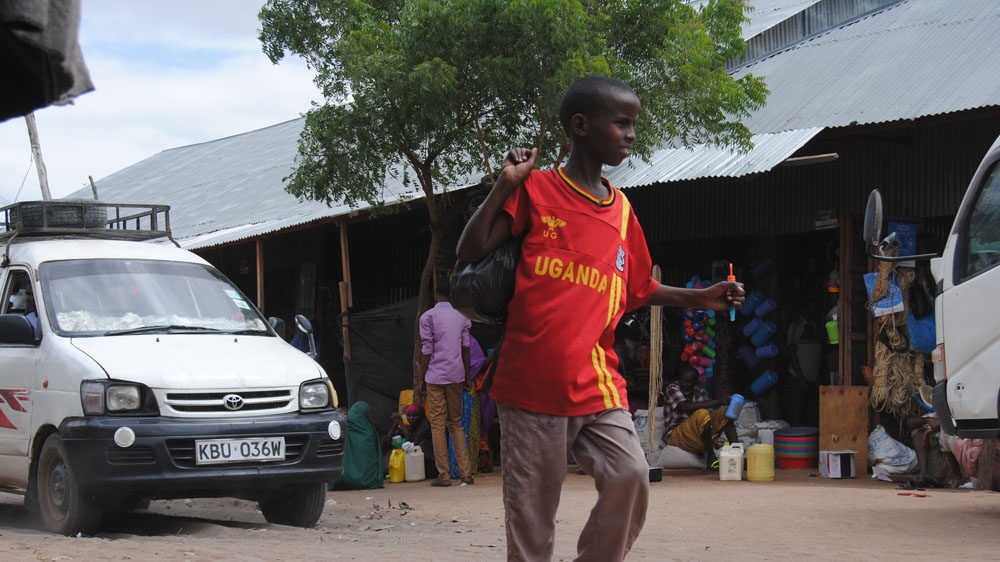 A young boy leaves the market place at Hagadera camp in Dadaab [Anthony Langat/Al Jazeera] 