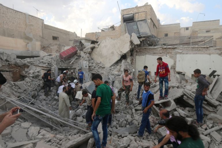 Men look for survivors under the rubble of a damaged building after an airstrike on Aleppo''s rebel held Kadi Askar area