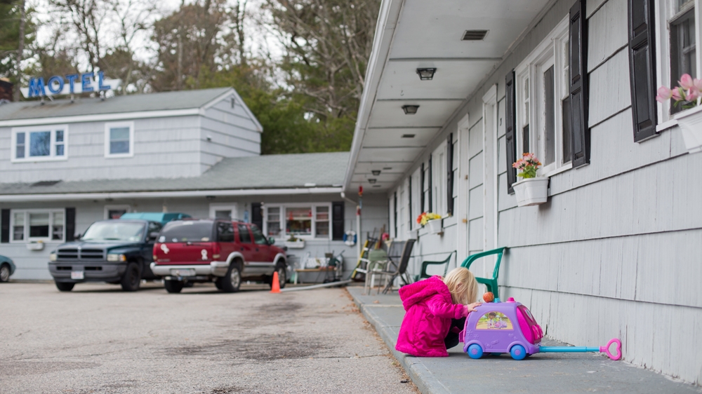 Sofiya plays in the parking lot of the motel as her mother, Tiffany, keeps watch. She wants to play with her eight-year-old half brother Colby, but he has homework to do [Carolyn B/Al Jazeera]
