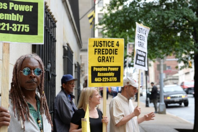 A small group of protesters stand outside of the courthouse in Baltimore