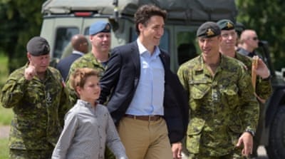Justin Trudeau and his son Xavier walk with Canadian soldiers during a visit to a joint military training in Ukraine [EPA]