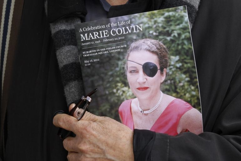 A man holds a sign honoring Sunday Times journalist Marie Colvin after a memorial service, outside St Martin in the Field in London