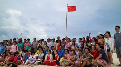 Chinese tourists pose on an island [Bo Gu/Al Jazeera]