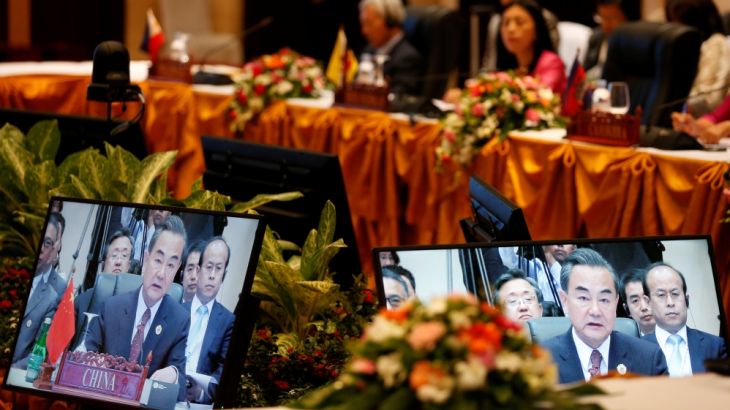 China''s Foreign Minister Wang Yi is seen on screens while speaks during a meeting with ASEAN foreign ministers in Vientiane