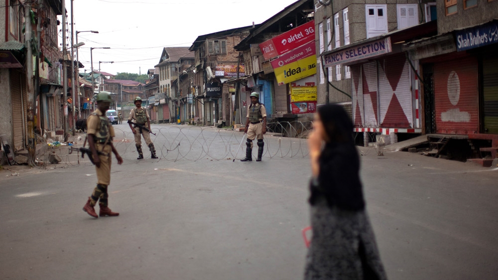  Indian government forces guard the deserted main road during a curfew following violence [Yawar Nazir/Getty Images]