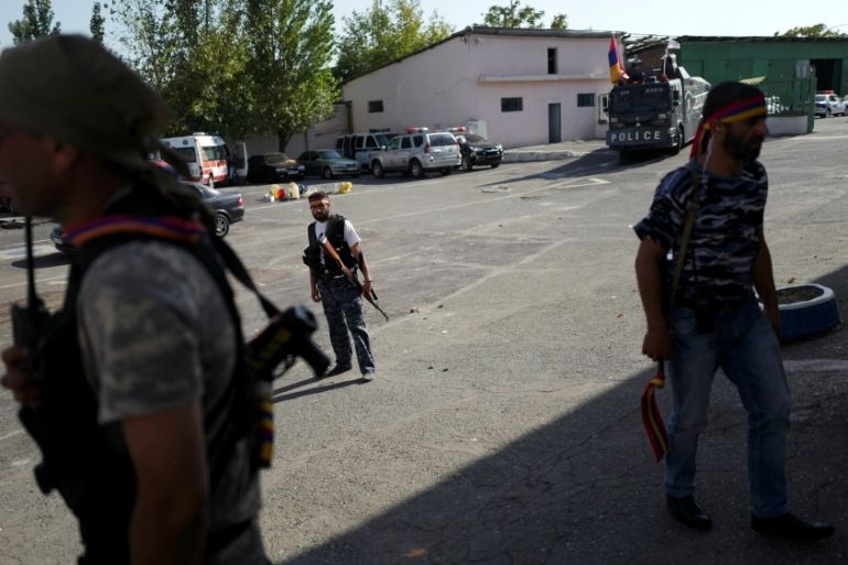 Armed men walk inside the Erebuni police station seized by "Sasna Tsrer" movement members in Yerevan