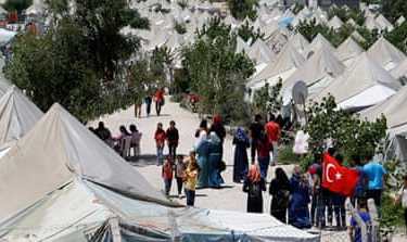 Syrian refugees stroll at a refugee camp in Osmaniye