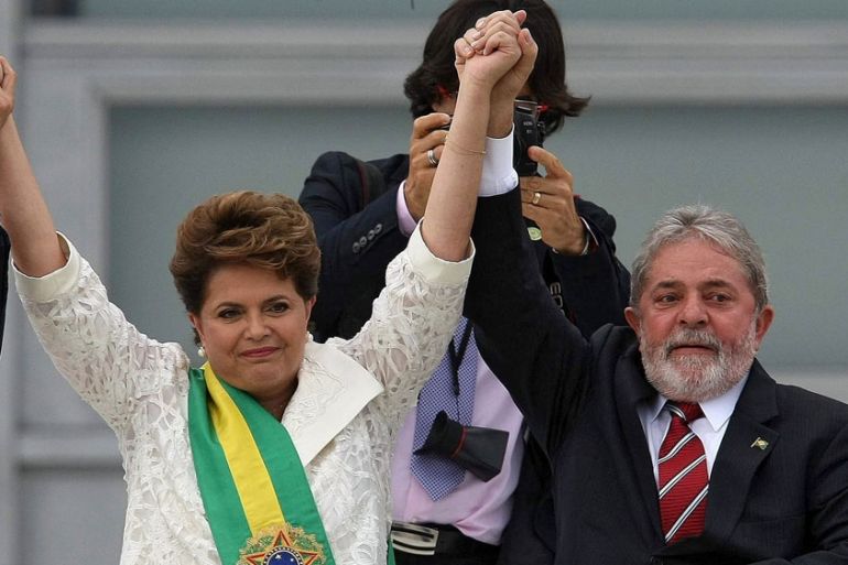 Brazil''s former President Luiz Inacio Lula da Silva listens as suspended President Dilma Rousseff addresses supporters, after the Brazilianlaws, at Planalto Palace in Brasilia