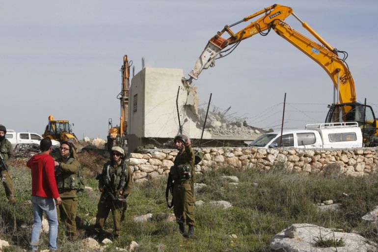 Palestinian man argues with Israeli soldiers during the demolition of a Palestinian house at the order of the Israeli army as he tries to stop the demolition, west of Hebron