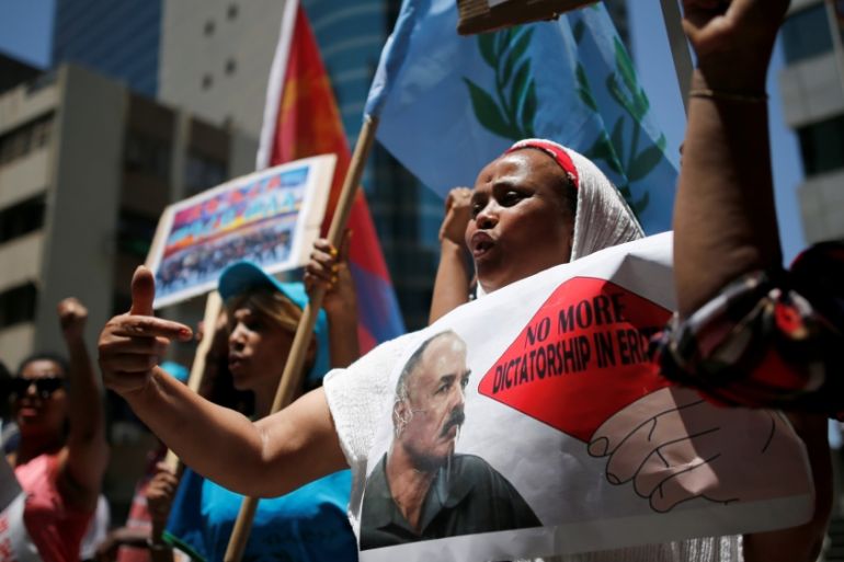 An Eritrean refugee holds a placard depicting Eritrea''s President Isaias Afwerki during a demonstration in support of a recent U.N. report that accused Eritrean leaders of committing c