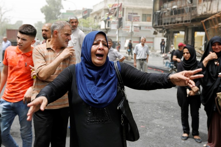 A woman reacts at the site after a suicide car bomb attack at the shopping area of Karrada, a largely Shi''ite district, in Baghdad