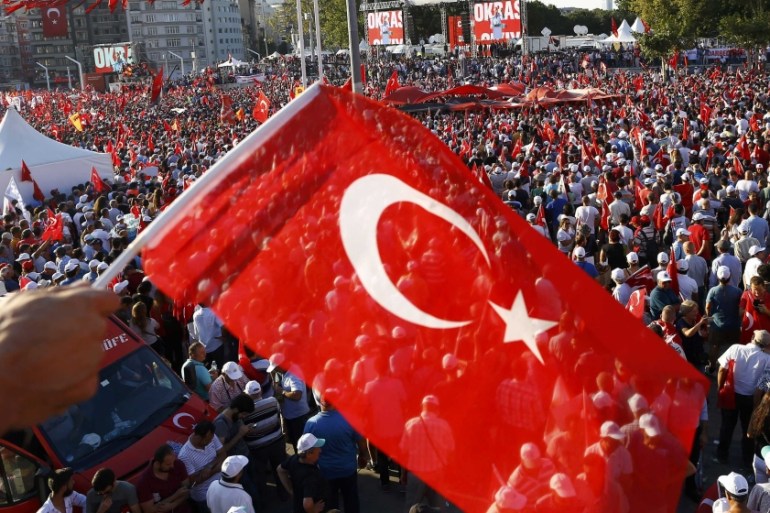 A man waves Turkey''s national flag as he with supporters of various political parties gathers in Istanbul''s Taksim Square