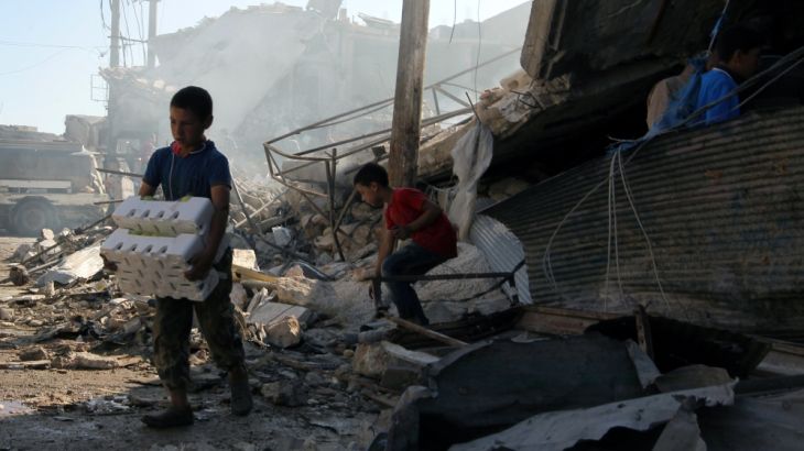 Boys salvage goods from a site hit by airstrikes in the rebel held town of Atareb in Aleppo province