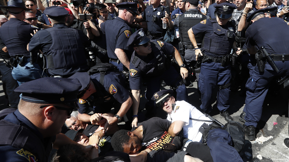 Police and protesters fall to the ground during Wednesday's demonstration [John Minchillo/AP]