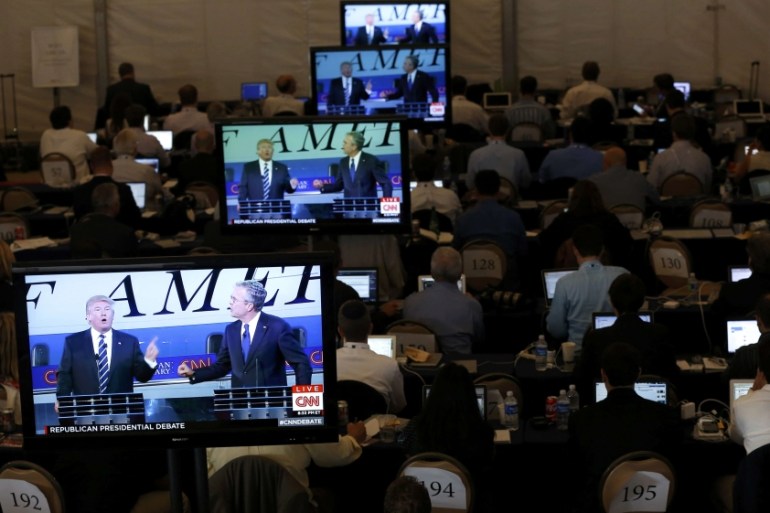 Members of the news media watch on TV monitors in the media center as U.S. presidential candidates Trump and Bush debate during the second Republican debate of the 2016 U.S. presidential campaign at t