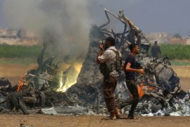 Men inspect the wreckage of a Russian helicopter that had been shot down in the north of Syria''s rebel-held Idlib province