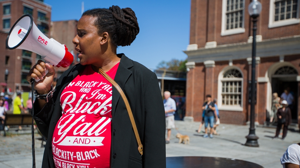 Nia Evans speaks to the crowd of protesters outside Faneuil Hall   [Carolyn Bick/Al Jazeera]  