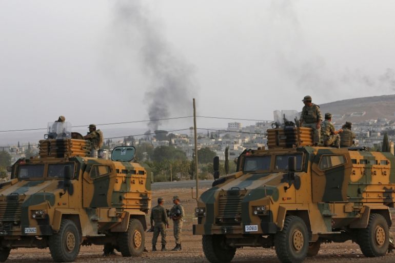 Turkish soldiers are seen with armoured vehicles near the Mursitpinar border crossing on the Turkish-Syrian border