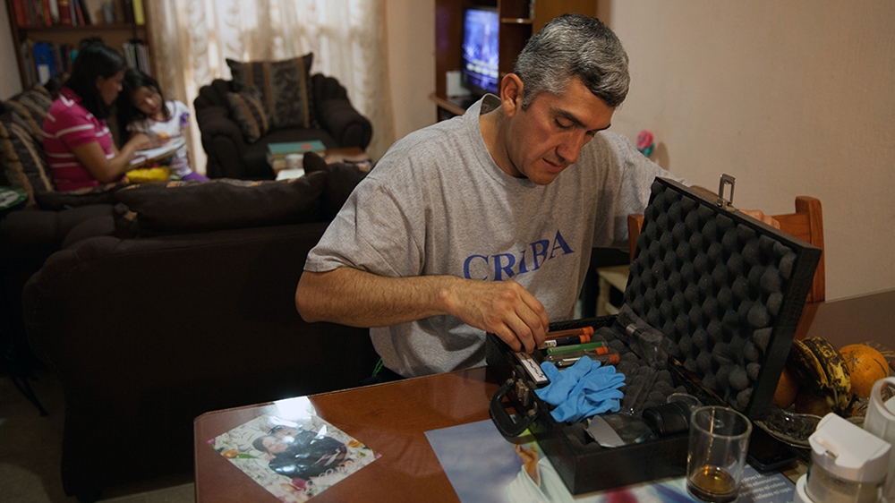 Donovan chooses chemical formulas for his forensic cleaning kit at his home in Texcoco, Mexico on May 21, 2015. He prefers not to write down or otherwise record the 370 formulas he has memorised so that they cannot be stolen [Benedicte Desrus/Al Jazeera]