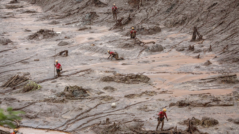 Rescue workers search for survivors trapped in the mud [Al Jazeera]