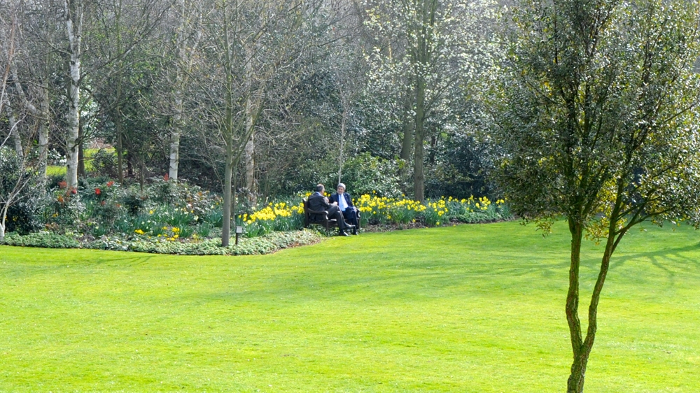 Kerry, right, and Lavrov sitting on the edge of the lawn at Winfield House, the US ambassador's residence in London, March 2014 [EPA]