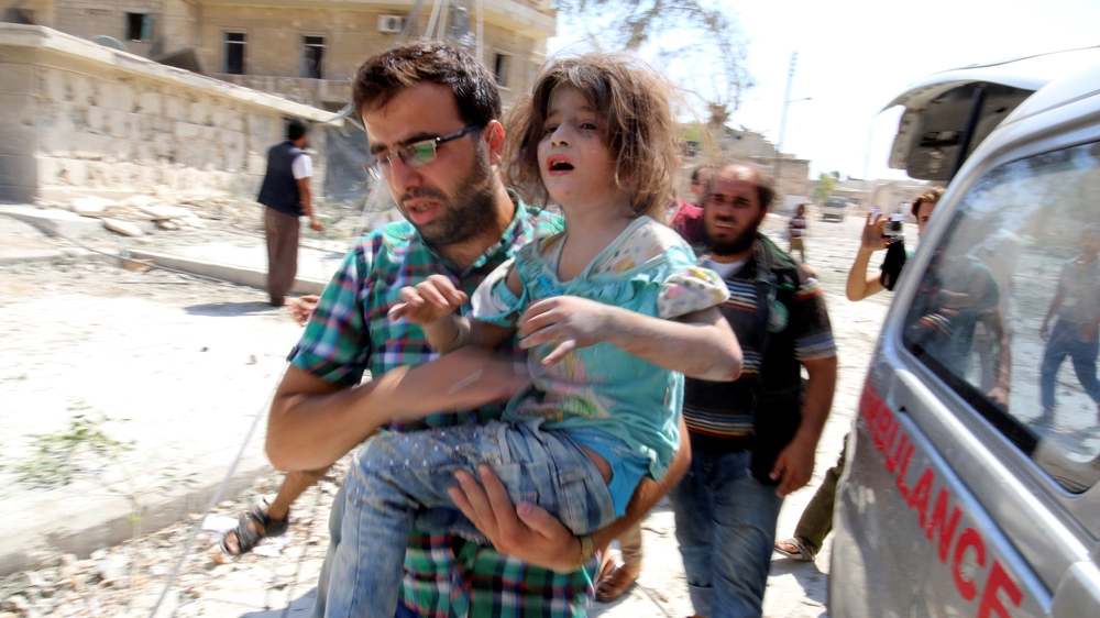 A man carries a girl who survived double air strikes on Saturday in a rebel-held neighbourhood of Aleppo [Abdalrhman Ismail/Reuters]