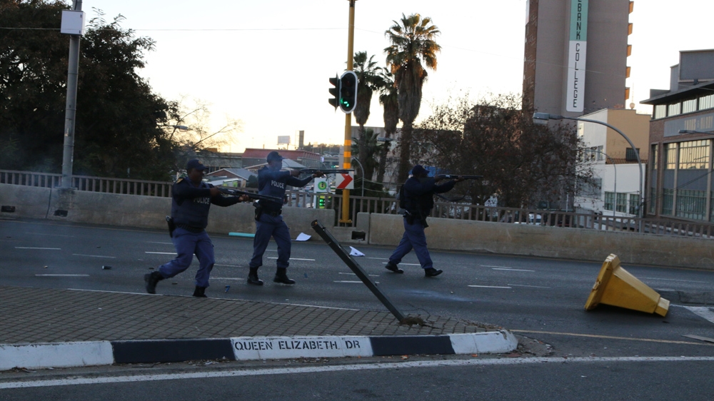 Police use stun grenades and rubber bullets to disperse protesting students on the Nelson Mandela Bridge in Johannesburg [Caelainn Hogan/Al Jazeera]