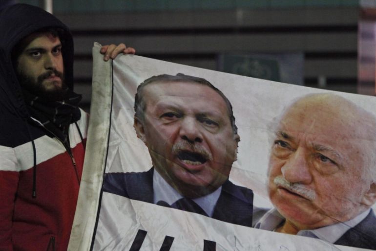 A demonstrator hold pictures of Turkey''s PM Erdogan and Turkish cleric Gulen, during a protest in Istanbul