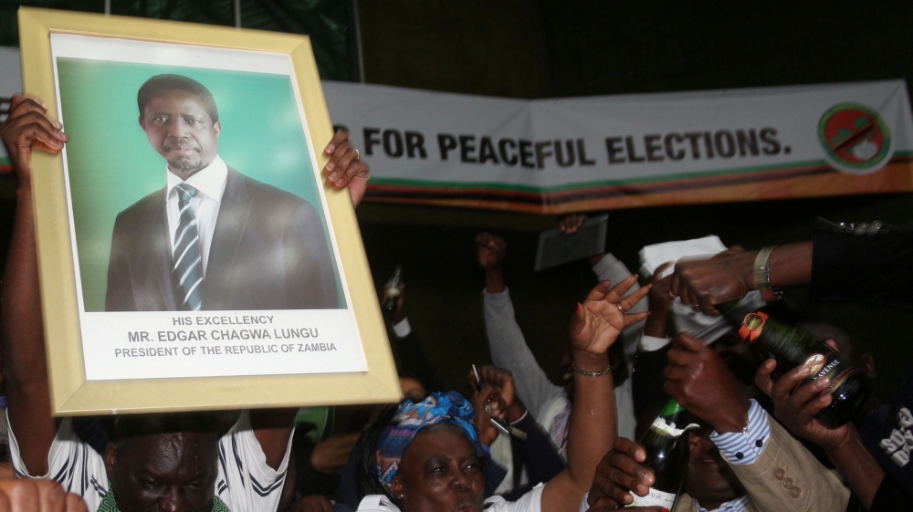PF supporters in Lusaka celebrate while holding a portrait of Lungu [Jean Serge Mandela/Reuters] 