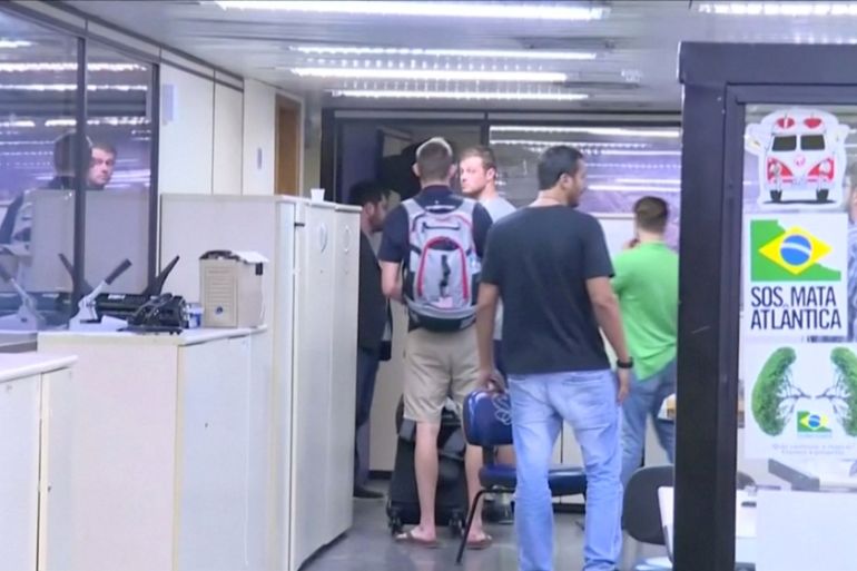 U.S. Olympic swimmers Gunnar Bentz and Jack Conger walk inside the airport police station office at Rio''s international airport in this still frame taken from video