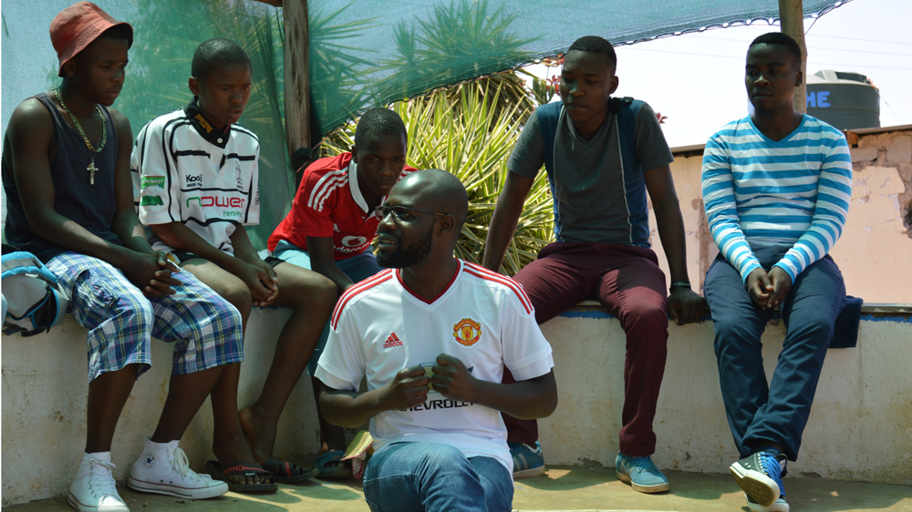 Sympathy Mpofu, a health practitioner and Kwakha Indvodza volunteer facilitator, talks to young men about their health [Tom Churchyard/Al Jazeera]