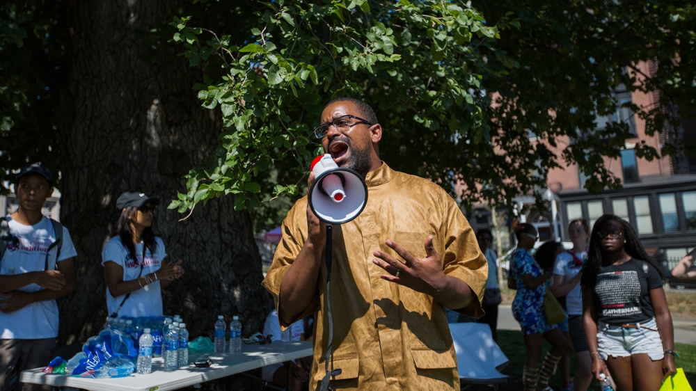 Rahsaan Hall, centre, addresses the protesters on Boston Common at the end of the rally [Carolyn Bick/Al Jazeera] 
