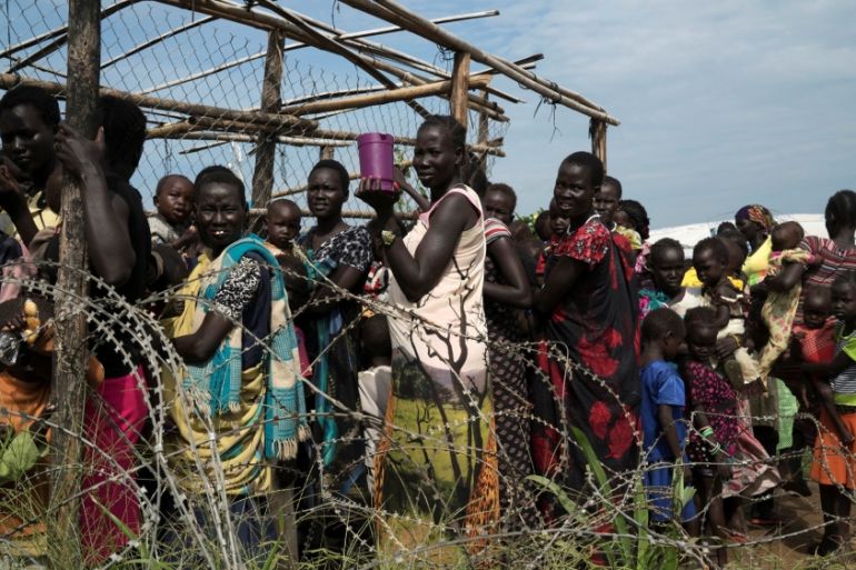 Women and children queue to receive emergency food at the U.N. protection of civilians site 3 hosting about 30,000 people displaced during the recent fighting in Juba